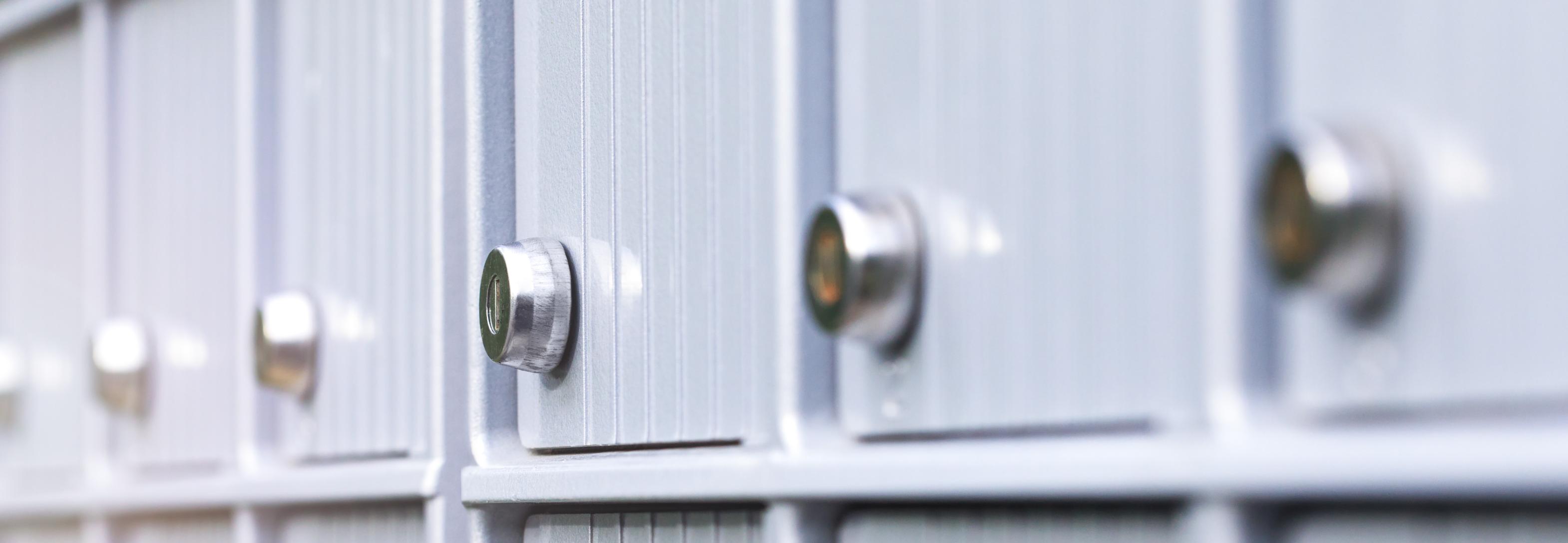 A bank of silver, square mailboxes