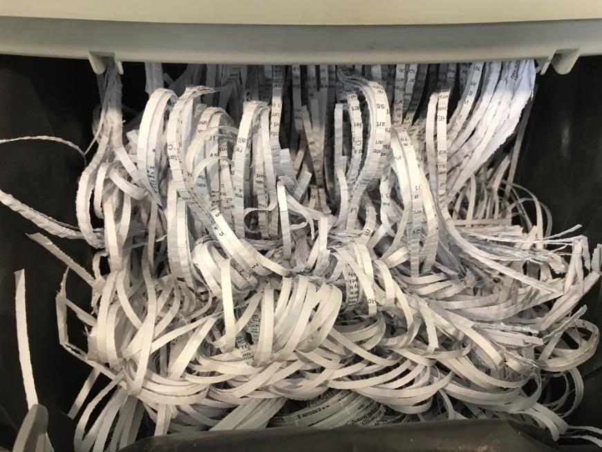 A document being shredded into small strips